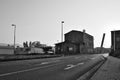 Litomerice, Czech republic - May 19, 2018: asphalt road leading around old historical industrial building and parked cars to shopp