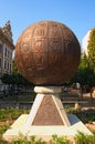 Unusual monument in the form of a metal ball with embossed pictures. Close up photo