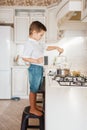 Litte boy cooking melt chocolate on the kitchen