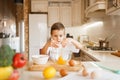 Litte boy stirs raw eggs in a bowl