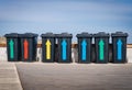 Litter bins with multi-colored arrows near the sea against the blue sky on the waterfront Royalty Free Stock Photo