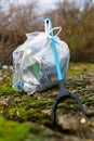 A litter picker and a full bag of rubbish that has been collected from a beach clean picking up discarded rubbish and litter.