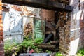 Littered room of an old abandoned house, a broken door and an old brick fireplace Royalty Free Stock Photo