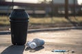 littering culprit, with empty water bottle and trash can in the background