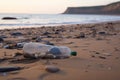 littering and urban pollution in the natural environment, with broken glass and plastic bottle on a beach