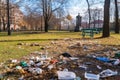 littering and urban pollution in a park, with trash strewn across the grounds