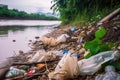 littering and urban pollution of river bank with plastic bags, bottles, and packaging