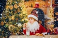 Littl child Santa eating cookies and drinking milk on Christmas tree. Little Santa picking cookie and glass of milk at Royalty Free Stock Photo