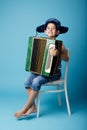Little accordion player on blue background Royalty Free Stock Photo