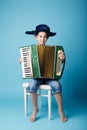 Little accordion player on blue background Royalty Free Stock Photo