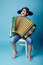 Little accordion player on blue background Royalty Free Stock Photo