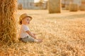 Little adorable baby boy with big brown eyes in a hat sits in a Royalty Free Stock Photo