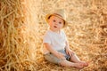 Little adorable baby boy with big brown eyes in a hat sits in a Royalty Free Stock Photo