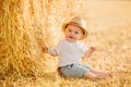 Little adorable baby boy with big brown eyes in a hat sits in a Royalty Free Stock Photo