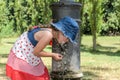 Little adorable baby girl drinks water from the drinking fountain of the roman nose on the streets of Rome Royalty Free Stock Photo