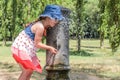 Little adorable baby girl drinks water from the drinking fountain of the roman nose on the streets of Rome Royalty Free Stock Photo