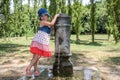 Little adorable baby girl drinks water from the drinking fountain of the roman nose on the streets of Rome Royalty Free Stock Photo