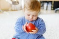Little adorable baby girl eating big red apple Royalty Free Stock Photo