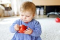 Little adorable baby girl eating big red apple. Vitamin and healthy food for small children. Portrait of beautiful child Royalty Free Stock Photo