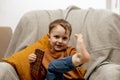 Little adorable boy sitting on the couch at home and eating chocolate bar. Child and sweets, sugar confectionery. Kid Royalty Free Stock Photo