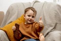 Little adorable boy sitting on the couch at home and eating chocolate bar. Child and sweets, sugar confectionery. Kid Royalty Free Stock Photo