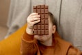 Little adorable boy sitting on the couch at home and eating chocolate bar. Child and sweets, sugar confectionery. Kid Royalty Free Stock Photo