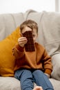 Little adorable boy sitting on the couch at home and eating chocolate bar. Child and sweets, sugar confectionery. Kid Royalty Free Stock Photo