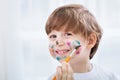 Little adorable child boy making a mess with colors on his face Royalty Free Stock Photo