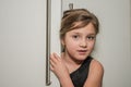 Little adorable girl child peeking out of the cabinet doors Royalty Free Stock Photo