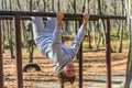 Little adorable girl child in a tracksuit trains on horizontal bars on the street in the autumn forest Royalty Free Stock Photo