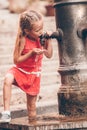 Little girl having fun with drinking water at street fountain in Rome, Italy