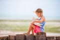 Little adorable girl reading book during tropical white beach Royalty Free Stock Photo