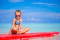 Little adorable girl on a surfboard in the