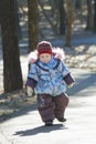 Little adorable girl toddling without help in cold weather park