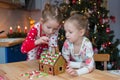 Little adorable girls decorating gingerbread house