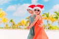 Little adorable girls in Santa hats during beach Christmas vacation having fun together Royalty Free Stock Photo