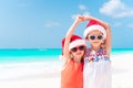 Little adorable girls in Santa hats during beach vacation have fun together Royalty Free Stock Photo