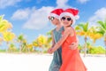 Little adorable girls in Santa hats during beach vacation have fun together Royalty Free Stock Photo