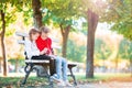 Little adorable girls with smartphone in fall outdoors. Kids having fun at warm sunny day in autumn park Royalty Free Stock Photo