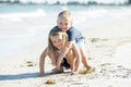 Little adorable and sweet siblings playing together in sand beach with small brother hugging his beautiful blond young sister enjo Royalty Free Stock Photo