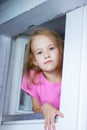Little adorable toddler girl looking through a window Royalty Free Stock Photo