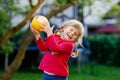 Little adorable toddler girl playing with ball outdoors. Happy smiling child catching and throwing, laughing and making