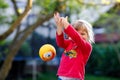 Little adorable toddler girl playing with ball outdoors. Happy smiling child catching and throwing, laughing and making