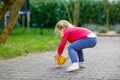 Little adorable toddler girl playing with ball outdoors. Happy smiling child catching and throwing, laughing and making Royalty Free Stock Photo