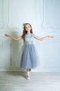 A little adorable young ballerina in a playful mood in the inter