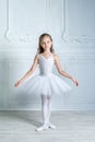 A little adorable young ballerina in a playful mood in the inter