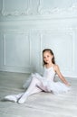 A little adorable young ballerina in a playful mood in the inter