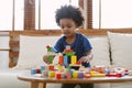 Little African american boy building a small house with colorful wooden blocks in living room at home. Educational toys for Royalty Free Stock Photo