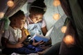 Little African-American children reading bedtime story in hovel Royalty Free Stock Photo