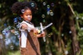 Little African American curly hair girl playing on park playground in spring or summer season. They enjoy climbing on the rope equ Royalty Free Stock Photo
